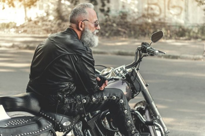 Motorkář v kožených kalhotách a bundě