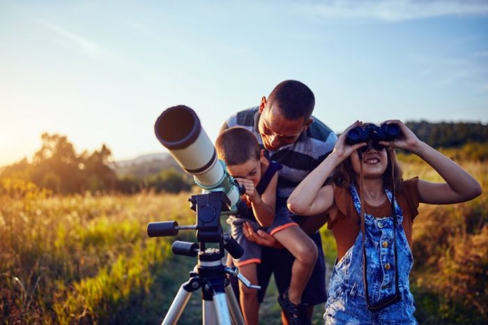 Rodina pozorující oblohu v přírodě pomocí teleskopu