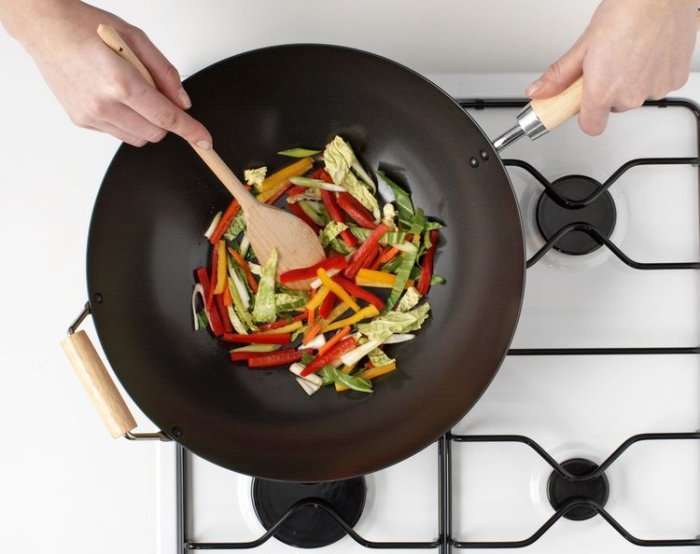 Príprava zeleniny v železnej wok panvici