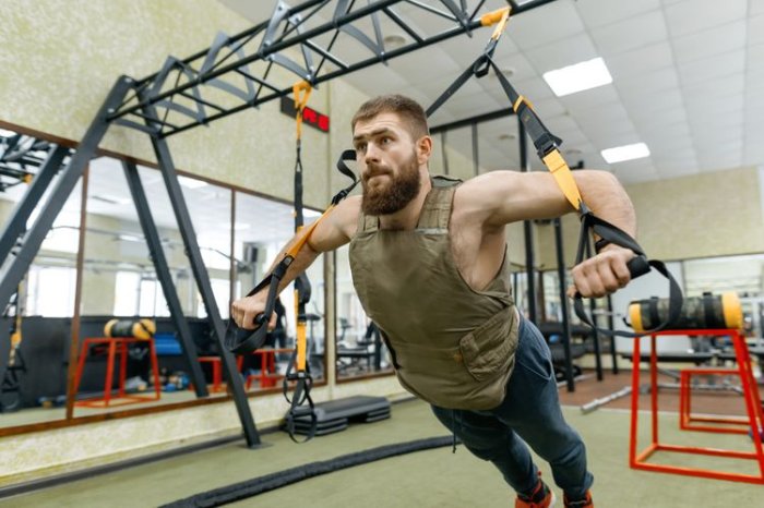 Trénink ve fitness centru se zátěžovou vestou